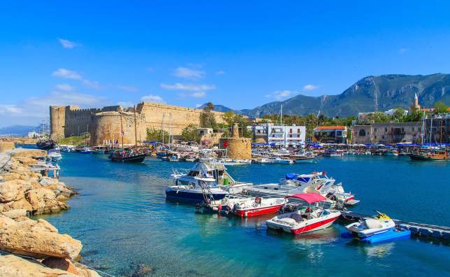 Boats in a port in Kyrenia Girne with castle in the background Cyprus