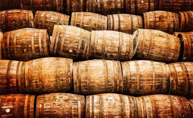 Stacked-pile-of-old-whisky-and-wine-wooden-barrels-in-vintage