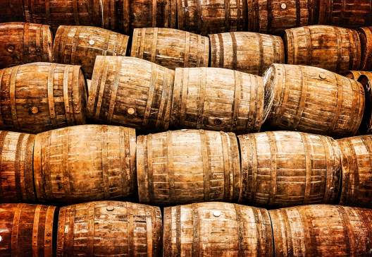 Stacked-pile-of-old-whisky-and-wine-wooden-barrels-in-vintage