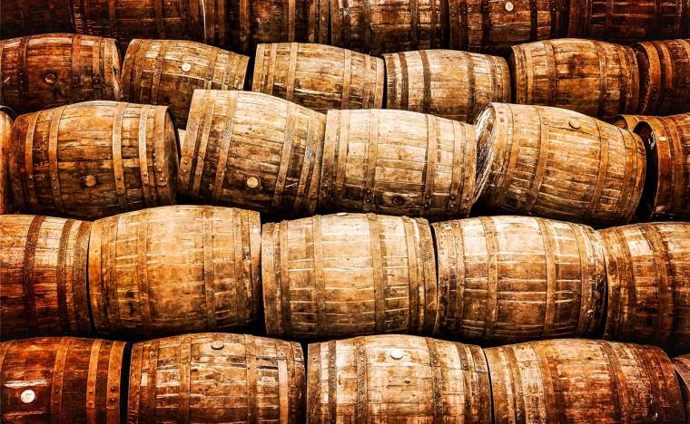 Stacked-pile-of-old-whisky-and-wine-wooden-barrels-in-vintage