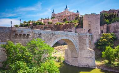 Panorama of the alcazar above the medieval San Martin bridge Toledo Spain