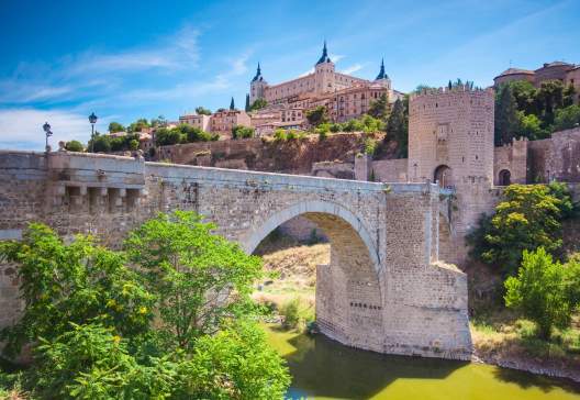 Panorama of the alcazar above the medieval San Martin bridge Toledo Spain