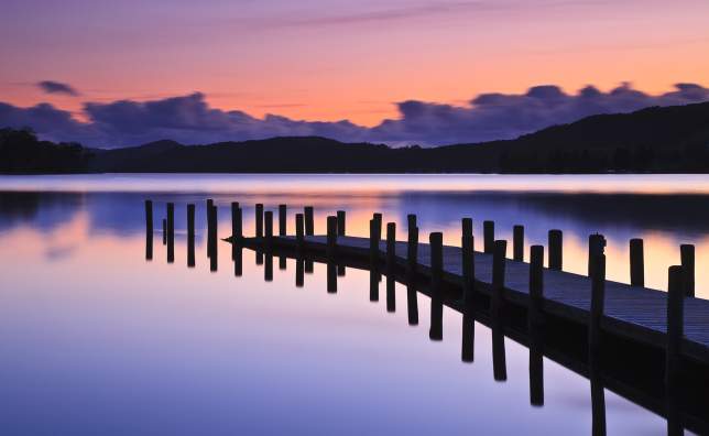 A-jetty-reflected-in-the-still-water-of-Coniston-Water-at-sunset