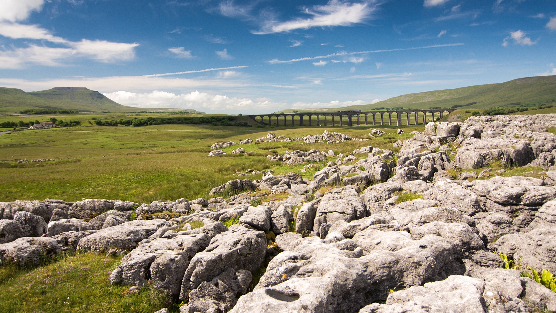 A-train-crossing-Ribblehead-Viaduct-in-the-Yorkshire-Dales-on-a-sunny-day-shot-from-the-limestone-pavement