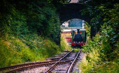 Steam train arriving at the railway train station