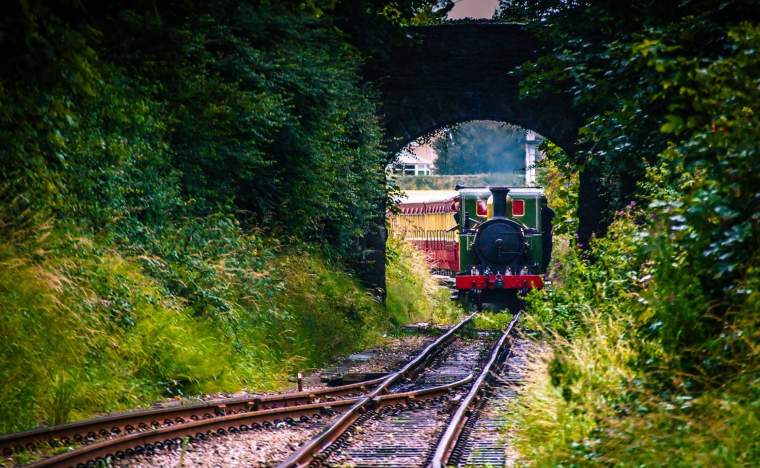 Steam train arriving at the railway train station